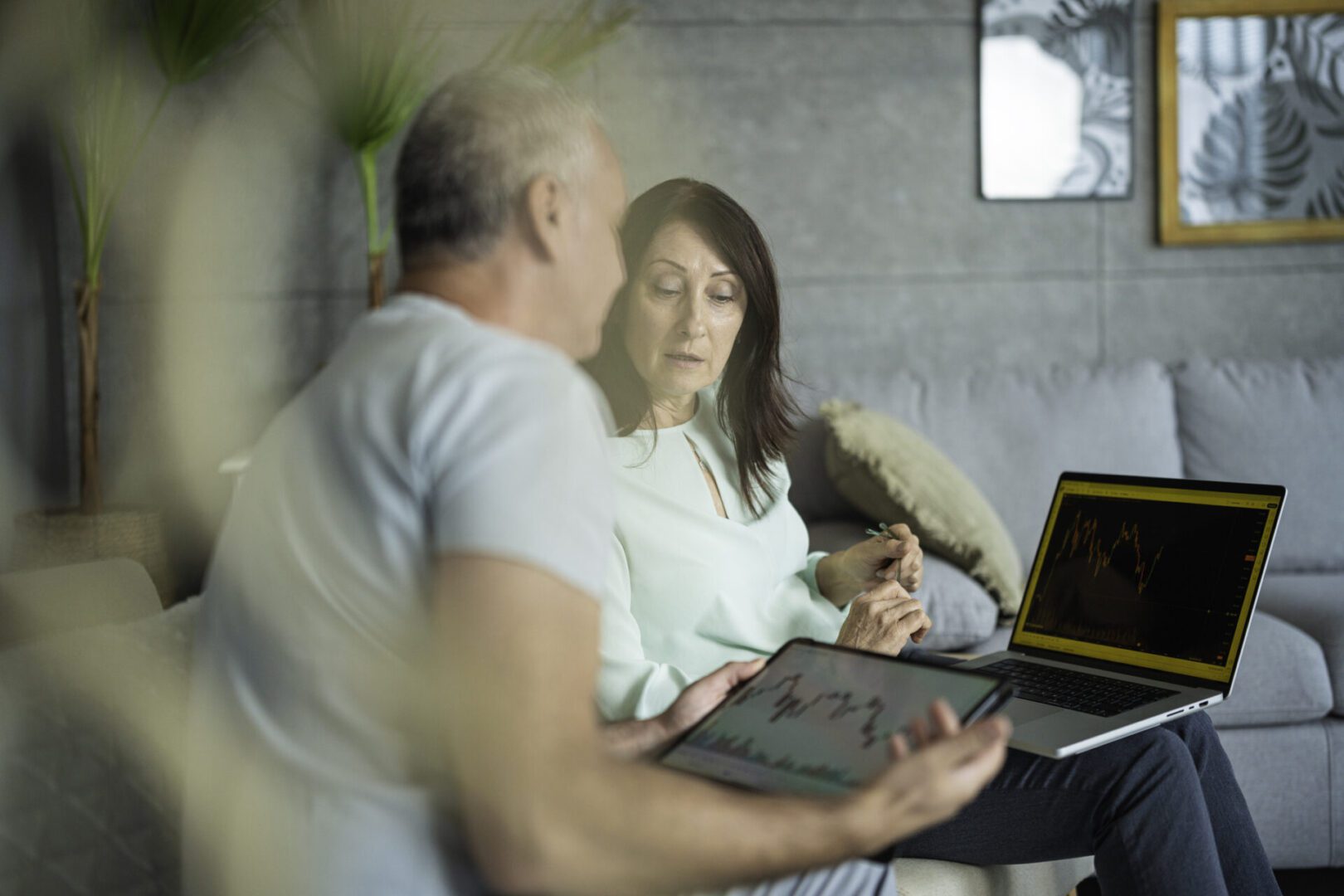 Personal finances and investments for the family. Tele Finances. Mature couple checking on trading positions and stock markets on TradingView app.