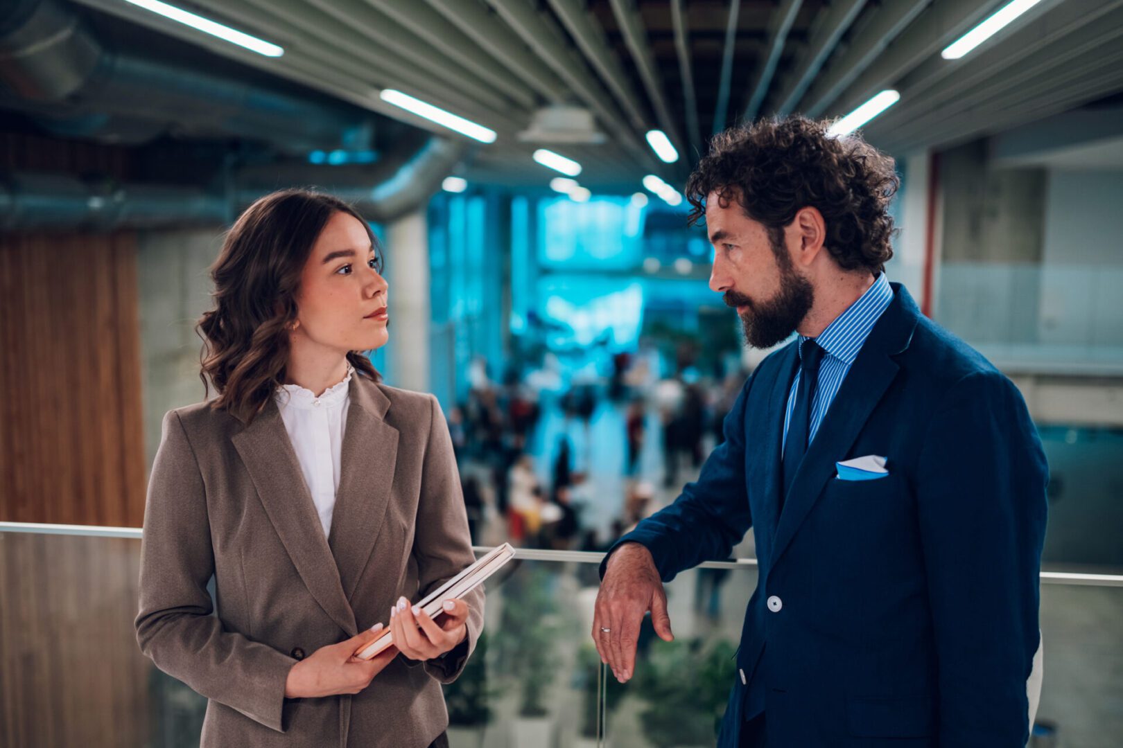 Businessman and businesswoman talking during a coffee break in the hall of a modern office building